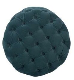Velvet-upholstered ottoman with solid wood frame and pocket springs, displayed in a cozy lounge.