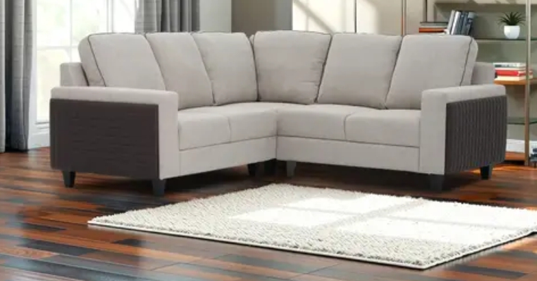 L-shaped beige leather lounge with dark brown armrests on wooden flooring in a modern living room